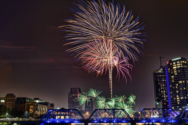 Multicolored fireworks above the blue bridge in downtown Grand Rapids