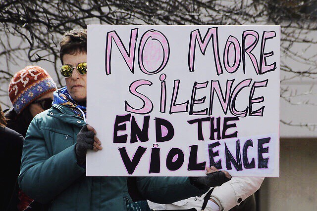 Marcher's sign reading, "No more silence, end the violence"