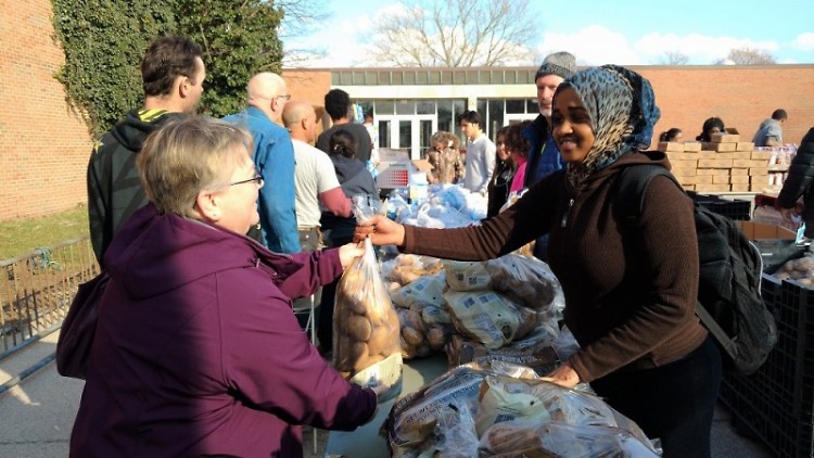 Senior Amina Abdullahi gives a bag of potatoes to a client at Union's Feb. 27 Mobile Pantry.