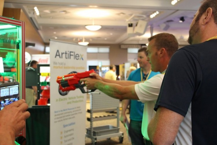 Expo attendee tests sharpshooting skills at ArtiFlex Automation game that uses industrial robot to pick out prizes.
