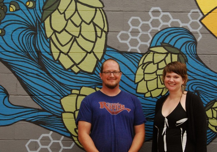 Barry VanDyke and Heather VanDyke-Titus stand in front of the mural painted on the outside of Harmony Brewing Company