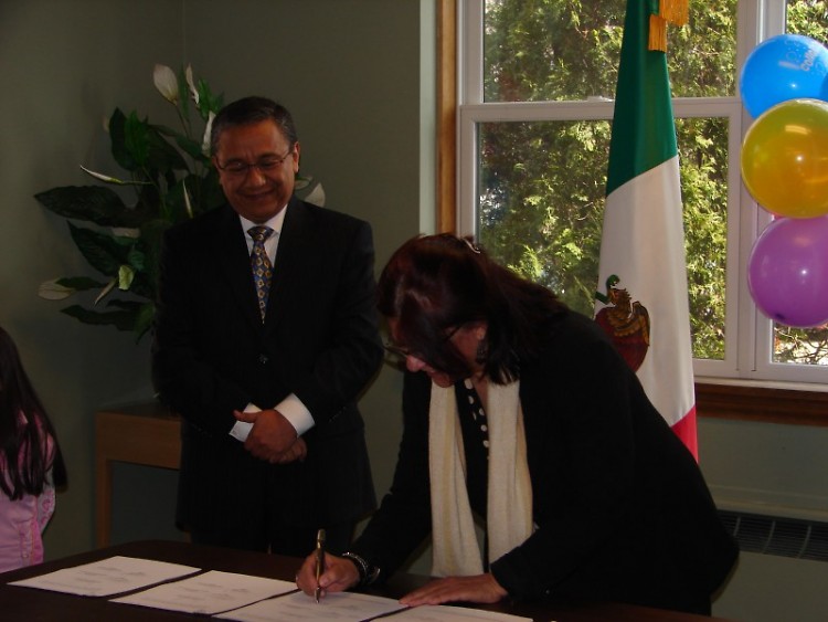 Sr. Vicente Sanchez of the Mexican Consulate and Co-Chair Zulema Moret sign the Plaza Comunitaria contract
