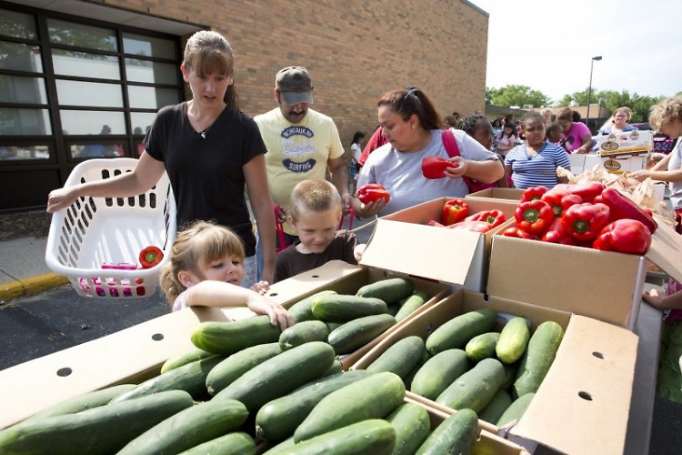 Sarah Crandall and her children gather groceries at a Feeding America West Michigan distribution in July. 