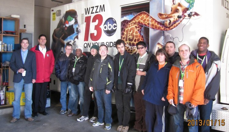 Dan Harland and Aaron Ofseyer pose with the HC1 students in front of the WZZM news vehicle entered into ArtPrize.