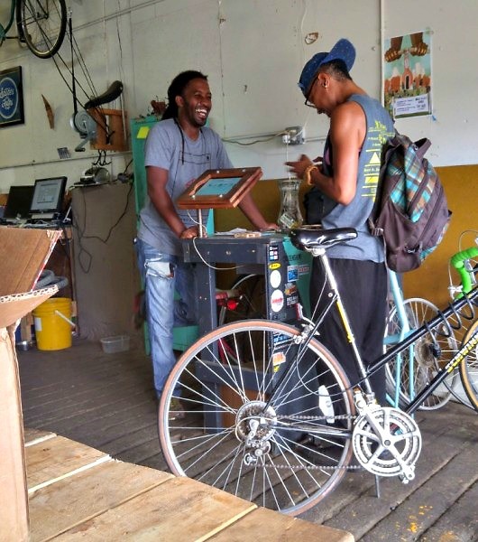 Martel Posey helping a patron after servicing their bike