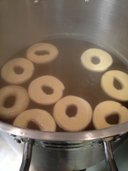 Some bagels beginning the boiling process.
