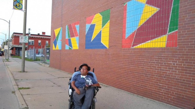 Javier Torres, Cultura Collective artist in front of his mural.