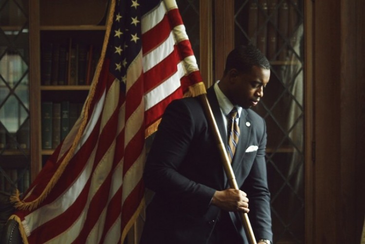 Leighton Watson posing with the American flag at Howard University