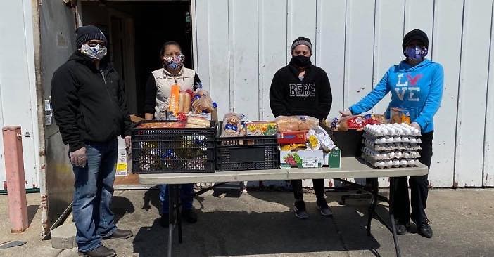 Miembros de Grand Rapids Area Mutual Aid Network (GRAMAN) distribuye alimentos a familias locales necesitadas.