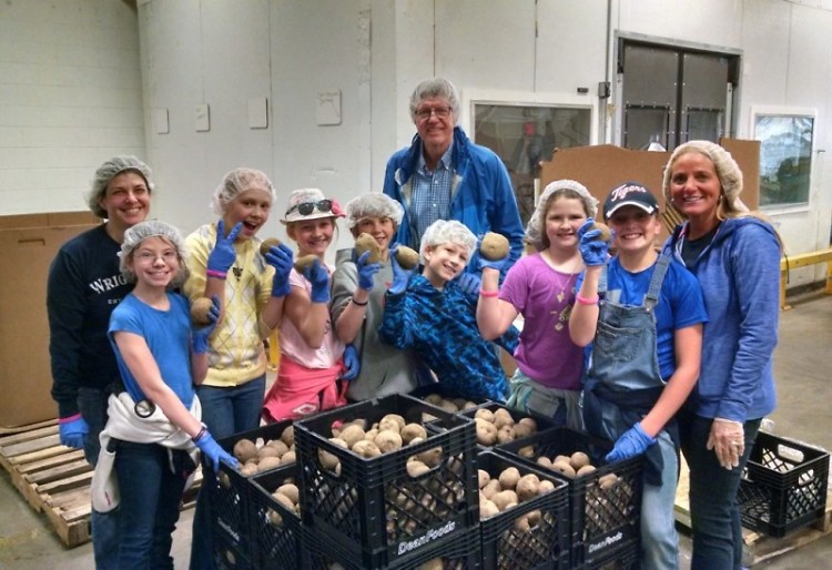 Fifth-grade students pack food at Feeding America West Michigan, April 22.