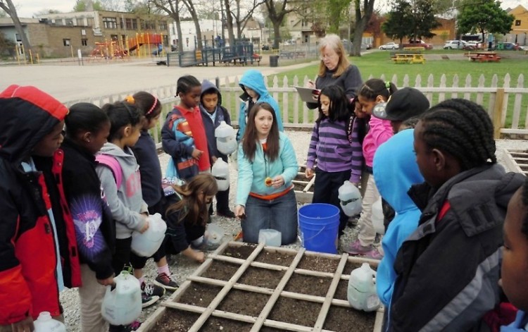 Renee Howard shows her third graders how to plant vegetables at the Congress Elementary School garden.