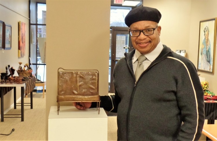 GRAAMA director George Bayard III stands with a replica of the Rosa Parks bus bench.