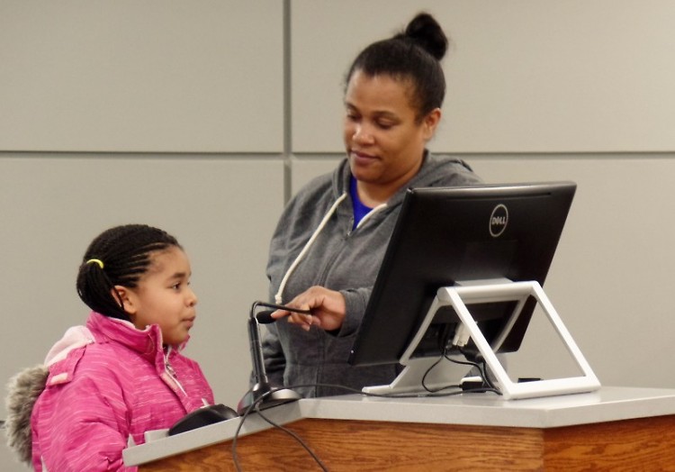 Raya Lewis (l) speaks to the Grand Rapids City Commissioners with the assistance of LaDonna Norman