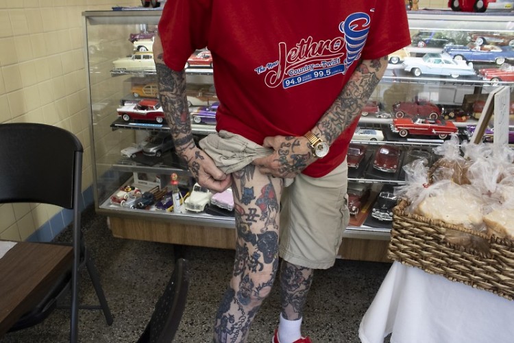 Teryl Grooters shows off his thigh tattoos. His arms and hands are also heavily tattooed.