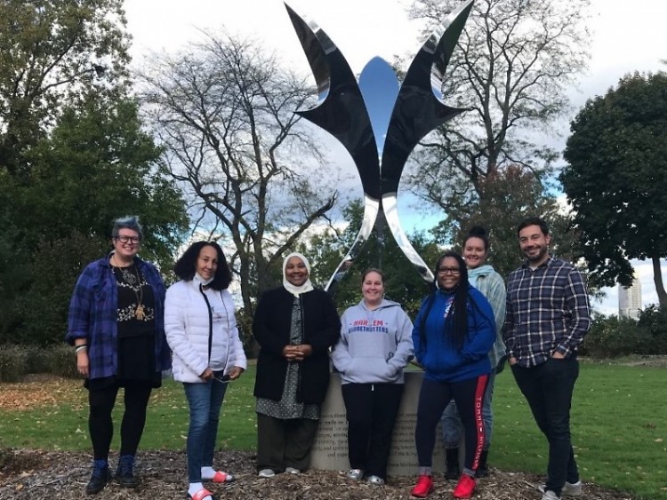 The BLBC Leadership Team poses in front of a statue in the Roosevelt Park neighborhood of Grand Rapids