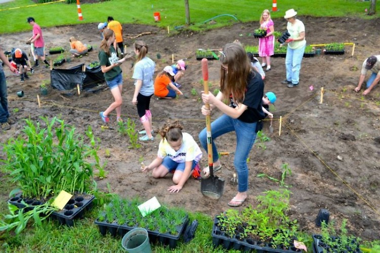 Volunteers from East Rockford Middle School partner with Michigan Trout Unlimited to plant deep-rooted native vegetation.