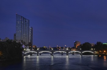 The lights on the bridges and buildings of downtown Grand Rapids lit up at nighttime.