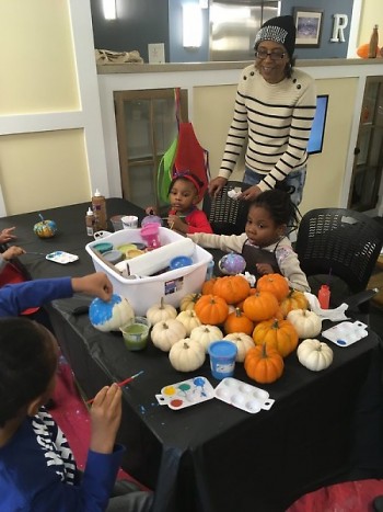 Young participants painted pumpkins to adorn their apartment buildings for the fall season