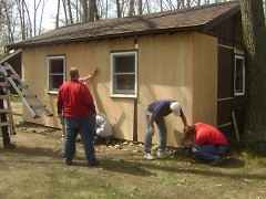 Lack Enterprises Plastic Plate Division's management team helps to reside a Camp O'Malley cabin.