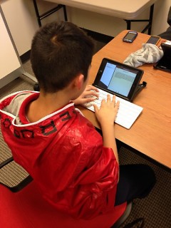 a Press Club member uses an iPad to write his story for The Rapidian