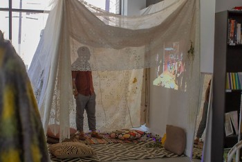 Inside the Cultivate Gallery, a guest explores the exhibit's lace-covered tent.