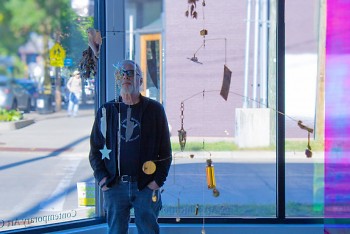 A visitor at the Cultivate Gallery gazes thoughtfully at a delicate mobile installation