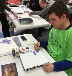 Reed working with paint during a free art session