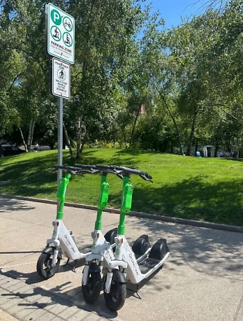 Lime scooters parked on the side of the street.