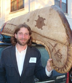 Kevin Finney stands by an authentic Ojibwe-style birch-bark canoe built last year by 50 fifth graders.