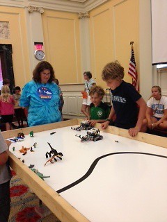 Tami Hartley watches as robots attempt to rescue mini-figs from dinosaurs