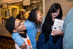 Student authors and a volunteer celebrate in the Wealthy Theatre lobby