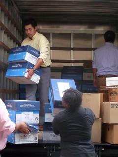 Varnum employees help to unload a truck full of school supplies at Buchanan Elementary.