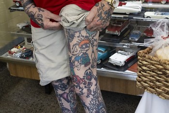 Teryl Grooters shows off his thigh tattoos, including Rugrats characters. His arms and hands are also heavily tattooed.