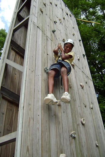 Camp O'Malley camper attempting to conquer the camp's climbing wall, one of the many fun, outdoor activities available!