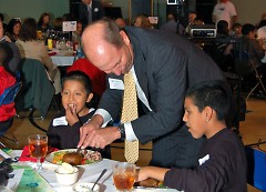 A sponsor helping the Club members at his table cut up their delicious steak dinners.